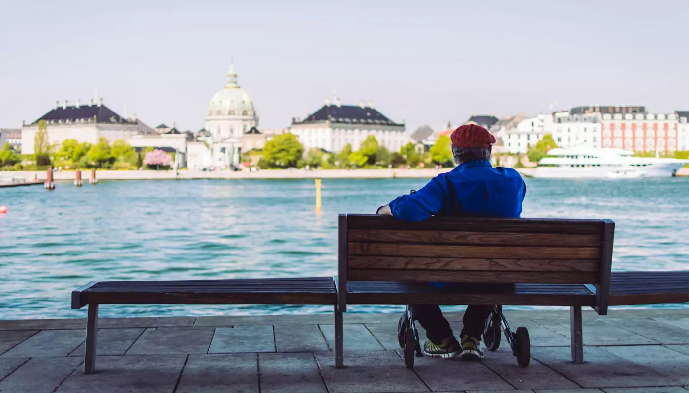 Alter Mann auf Bank am See